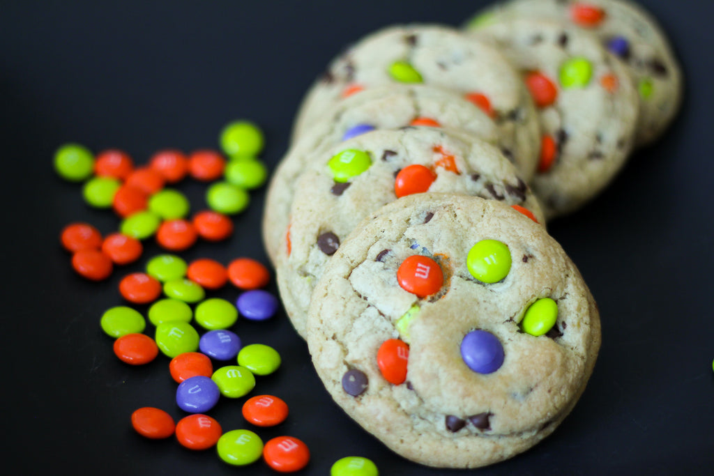 pile of M&M cookies with orange, green and purple M&Ms