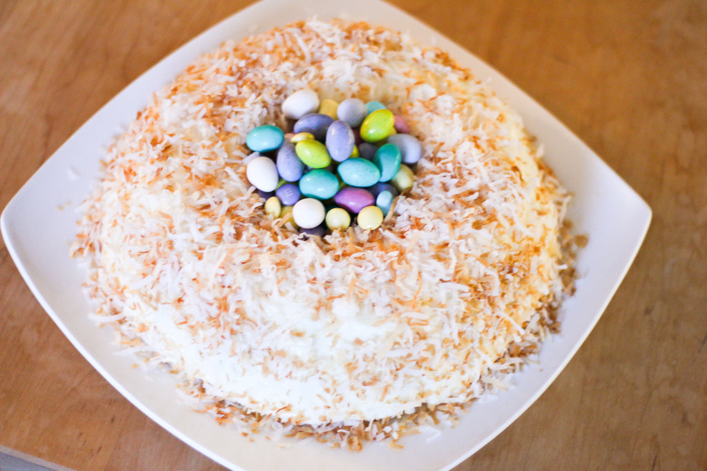 vanilla bundt cake topped with shredded coconut and filled with easter candy in the center