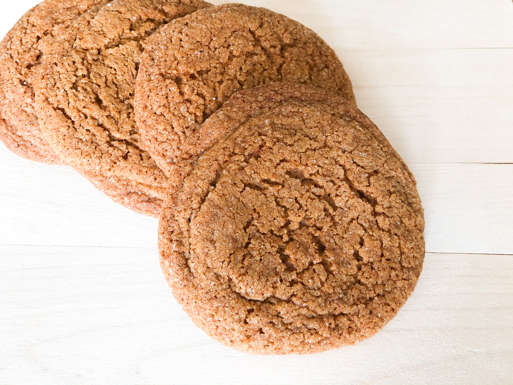 stack of 4 ginger molasses cookies on a cutting board